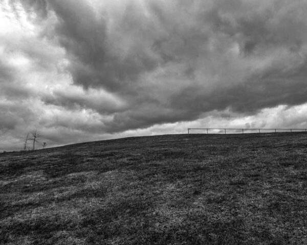 photograph of a dramatic sky under a curved ridgeline