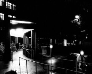 A nighttime photograph of a man walking.